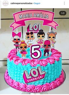 there is a birthday cake with pink and blue frosting on the top, decorated with cartoon characters