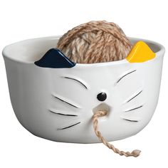 a ball of yarn in the shape of a cat's head is tied to a white bowl