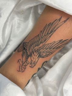 an eagle tattoo on the leg of a person