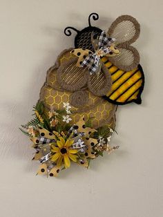 a yellow and black bee decoration hanging on the wall