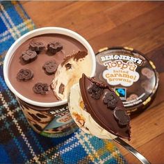 an ice cream sundae with chocolate cookies on top and a spoon next to it