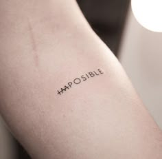 a person with a tattoo on their arm that says impossible