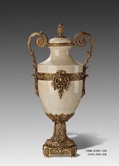 an ornately decorated vase is shown on a white surface with gold trimmings