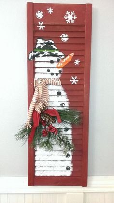 a snowman made out of shutters is hanging on the wall