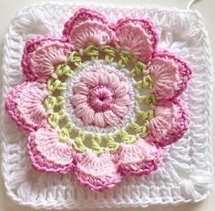 a crocheted square with pink flowers on it