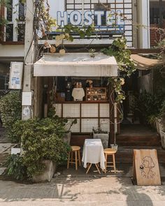 an outside view of a restaurant with tables and stools in front of the building