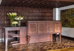 an ornately decorated room with wood paneling and flowers in vases on the table