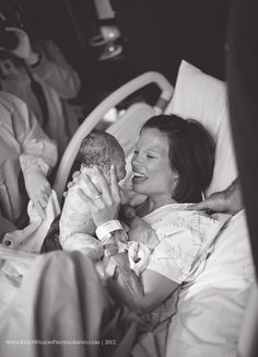 a woman holding a baby in a hospital bed