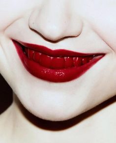 a woman's face with red lipstick and white teeth