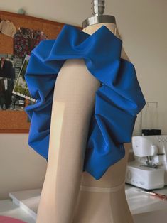 a mannequin wearing a blue top with a ruffle on it's back