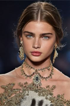 a model wearing an elaborate necklace and earrings