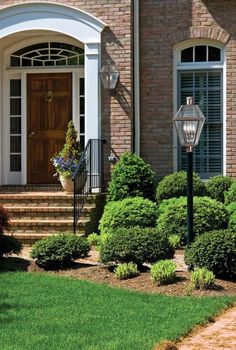 the front door of a brick house with landscaping around it