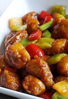 a close up of a plate of food with meat and vegetables in it on a table