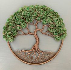 a tree with roots in the shape of a circle on a white surface, it appears to be made out of wire