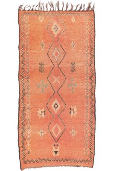 an orange rug with fringes on the edges and a diamond pattern in the middle