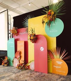 colorful paper cutouts with flowers and palm leaves are displayed in front of a backdrop