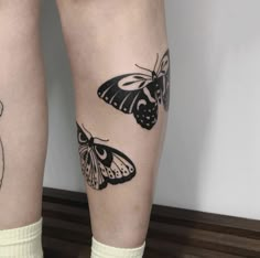 two butterflies on the legs of a woman