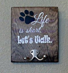 a sign that says life is short, let's walk with a paw on it