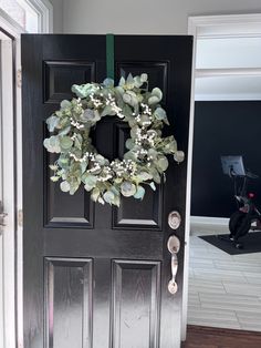 a black door with a wreath on it