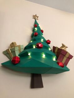 a christmas tree made out of folded paper with presents on it and lights around the top