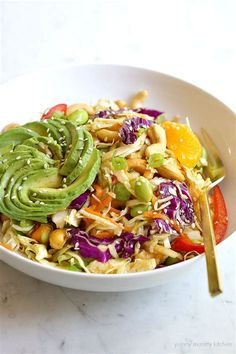 a white bowl filled with salad and topped with avocado