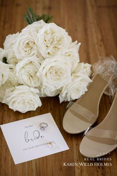 the bride's bouquet and shoes are on the floor next to her wedding card