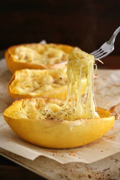 spaghetti being scooped out of an uncooked squash dish with a fork in it