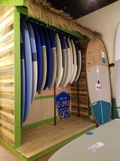 several surfboards are on display in a room with wood paneling and green trim