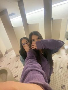 two women taking a selfie in the bathroom