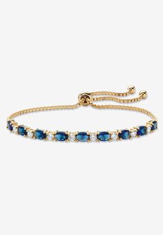 Color the day with classic style and vibrant color with this beautiful slider bracelet. Glimmering simulated blue sapphires and sparkling cubic zirconia ovals alternate on the adjustable bolo strand featuring ball ends that dangle in cool style. 6.20 carats T.W. 10" length. Richly plated in 14k yellow gold.14k Gold-PlatedMain Stone: 9 Oval Faceted Cut Simulated Blue Sapphires, 5.40 carats total weight, 6 mm x 4 mm8 Round Brilliant Cut Cubic Zirconias, .80 carat total weight, 3 mm x 3 mmDimension Gold And Blue Bracelet, Adjustable Blue Round Tennis Bracelet, Adjustable Blue Tennis Bracelet, Adjustable Sapphire Bracelets For Formal Events, Adjustable Sapphire Bracelets For Formal Occasions, Gold And Blue Jewelry, Blue And Gold Jewelry, Blue Jewlery, Ball Jewellery