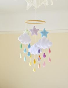 a crib mobile with clouds and rain drops hanging from it