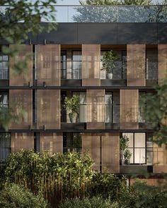 an apartment building with wooden balconies and plants on the outside, surrounded by greenery