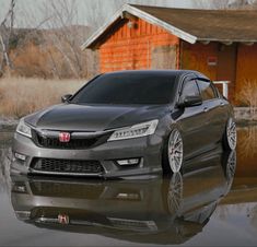 a gray car parked in front of a red house