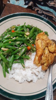 a white plate topped with rice and green beans