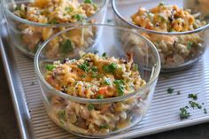 four clear bowls filled with food on top of a metal tray