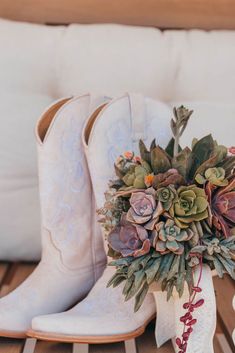 a bouquet of succulents sits next to cowboy boots