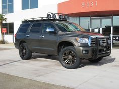 a truck parked in front of a building with its roof rack on it's flatbed