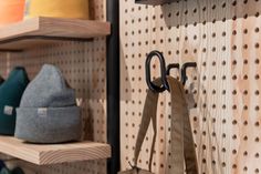 several pairs of shoes are hanging on the pegs in a store display area with wooden shelving