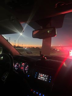 the interior of a car with its lights on at night, and an emergency vehicle in the background