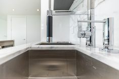 a stainless steel sink with chrome faucet and marble countertop in a bathroom