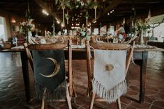 two wooden chairs sitting next to each other in front of a table filled with flowers