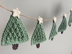 crocheted christmas trees are hanging on a line with twine and cotton yarn