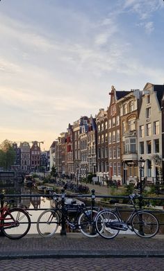 several bicycles are parked along the side of a canal