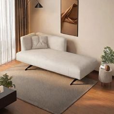 a white couch sitting on top of a rug in a living room next to a window