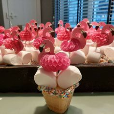 cupcakes with marshmallows and pink flamingos on them are arranged in an ice cream cone