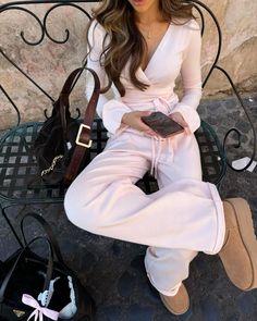 a woman sitting on top of a bench next to a purse