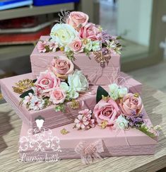 three pink boxes with flowers are stacked on top of each other