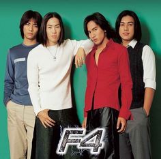 four young men standing next to each other in front of a green wall with the number 47 on it