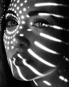 a woman's face is lit up with light from the sun shining through her eyes