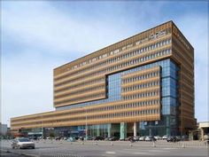 an office building with many windows and cars parked in the parking lot next to it